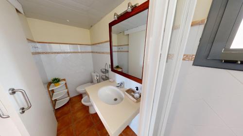 安波拉Citronella的一间带水槽、卫生间和镜子的浴室