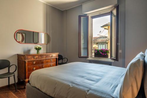 米兰Morigi 5 Vie的一间卧室配有一张床、一个梳妆台和一扇窗户。