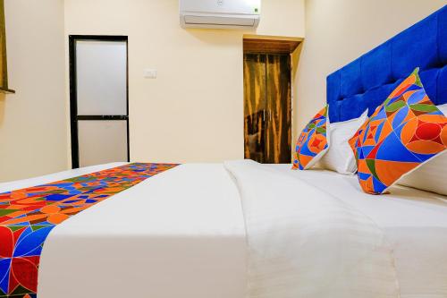 孟买FabExpress Kurla Inn的一间卧室配有两张白色床和色彩缤纷的枕头