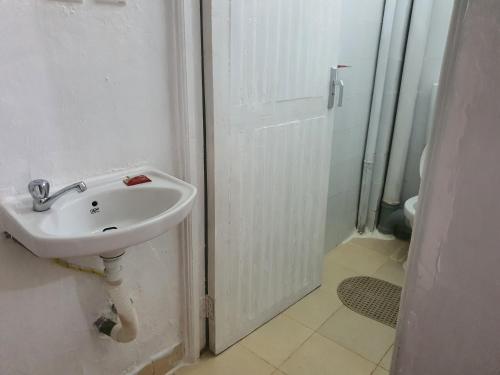 MeruFahari1的白色的浴室设有水槽和淋浴。