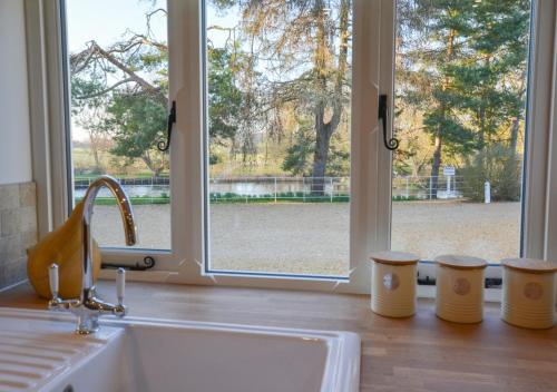 ElsingMill Cottage的带水槽的厨房台面和窗户