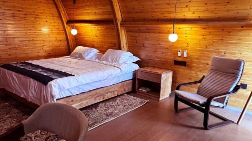 塞伦盖蒂国家公园Serengeti Ark Safari Lodge - Kogatende的小屋内一间卧室配有一张床和一把椅子
