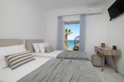 扎金索斯镇Swan Apartments的一间带两张床的卧室,享有海景