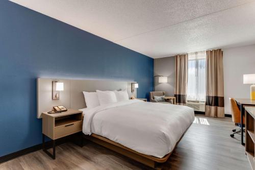 托马斯维尔Comfort Inn Thomasville I-85的一间卧室设有一张大床和蓝色的墙壁