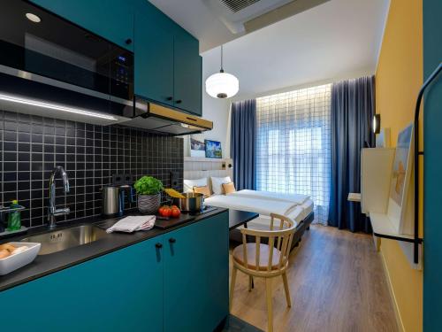 基尔Aparthotel Adagio Access Kiel的一个带水槽的厨房和一张位于客房内的床