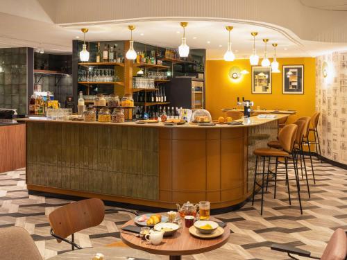 安锡Le Splendid Hotel Lac D'Annecy - Handwritten Collection的餐厅内的酒吧配有桌椅