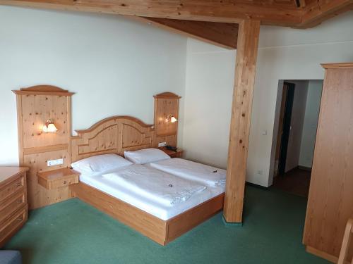 上陶恩Hotel Grünwaldkopf的一间卧室配有一张带木制家具的大床
