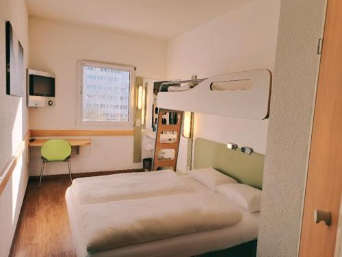 柏林ibis budget Berlin Ost的客房设有两张床、一张桌子和一张双层床。