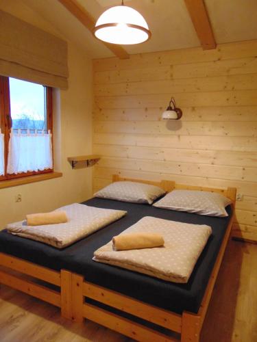 TrzebiniaPod Pagórkiem的小木屋内一间卧室,配有两张床