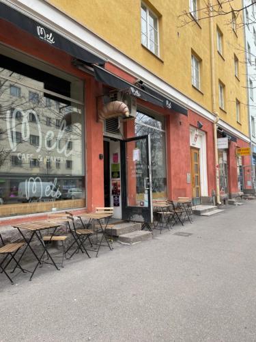 赫尔辛基Your Chic Vibrant Airbnb的街道上带桌椅的商店前