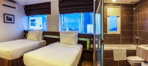 芽庄Ocean View Nha Trang的酒店客房设有两张床和淋浴。