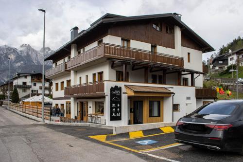 LorenzagoChalet Cridola Dolomiti Experience的前面有停车位的建筑