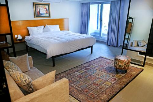 伊斯兰堡The Avenue Hotel的一间卧室设有一张床和一间客厅。