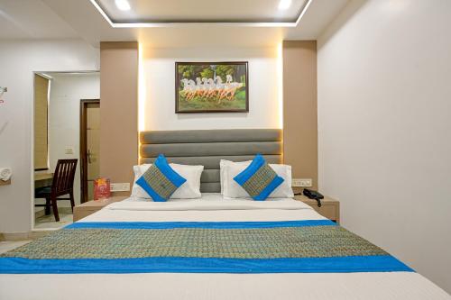 新德里Hotel Bhartia 2 min walk from New Delhi Railway station的一间卧室配有一张带蓝色和白色枕头的床