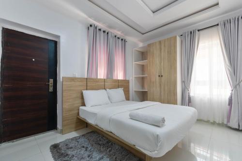 拉各斯Firenze Apartments Lekki的白色的卧室设有一张大床和一个窗户