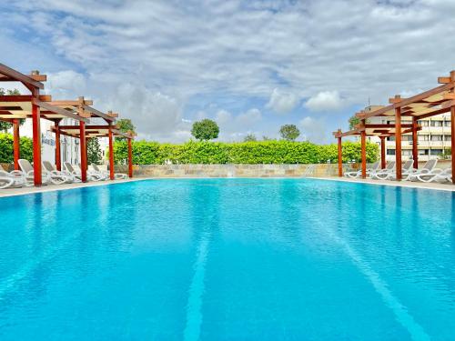安塔利亚客安贝斯特韦斯特酒店的一座带白色椅子和树木的大型蓝色游泳池
