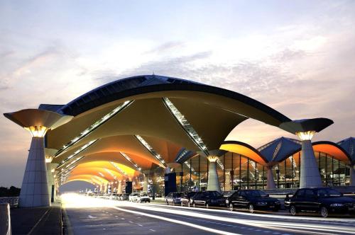 雪邦Kepler Club Kuala Lumpur Airport - KLIA T1 Landside的一座大型建筑,有汽车停在街上