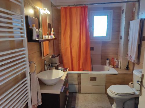 Villa Teodora的浴室设有橙色淋浴帘、水槽和卫生间