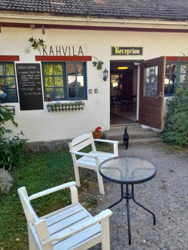 维塔萨里Wiikki Majatalo的餐厅前的两把椅子和一张桌子