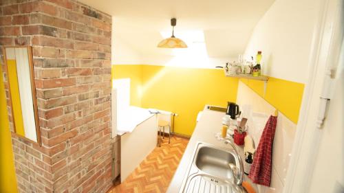 利耶帕亚曼丹尼公寓的厨房设有水槽和砖墙