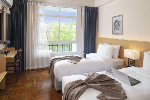 曼谷Ago Hotel Chinatown的酒店客房设有两张床和窗户。