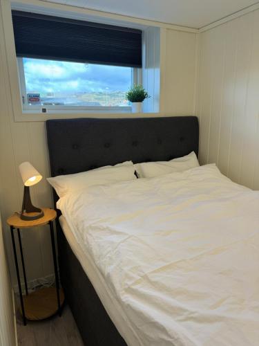 约尔珀兰Mini apartment in centre of Jørpeland的卧室配有白色的床和窗户