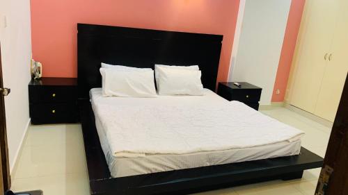 伊斯兰堡Serene Home Apartment (1-Bedroom)的一张床上,上面有黑色床头板