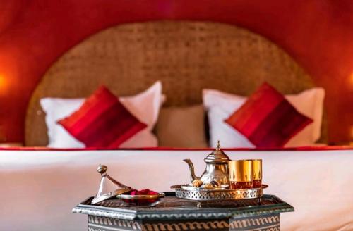 马拉喀什La Perle de l'Atlas by Golf Resort的床上的桌子和茶壶