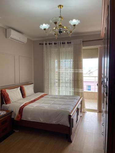 都拉斯LuxurySeaview Apartment的一间卧室配有一张带吊灯和窗户的床。