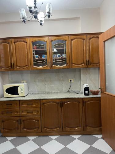 都拉斯LuxurySeaview Apartment的一间带木制橱柜和微波炉的厨房