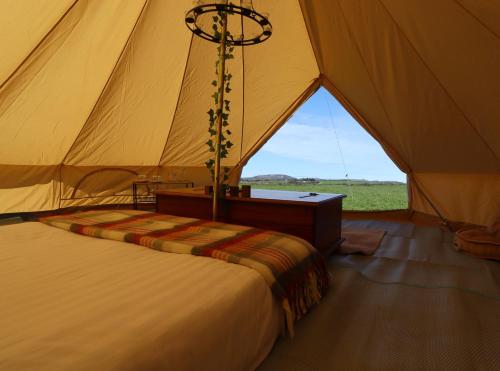 梅瓦吉西Rescorla Retreats- Poldark的帐篷配有一张床和一张桌子