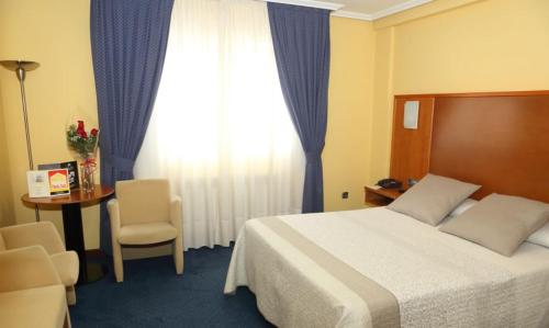 圣地亚哥－德孔波斯特拉Motel Punta Cana的酒店客房设有床、桌子和窗户。