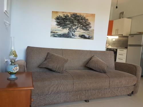基萨莫斯Elia Guesthouse的客厅的沙发,墙上有一棵树