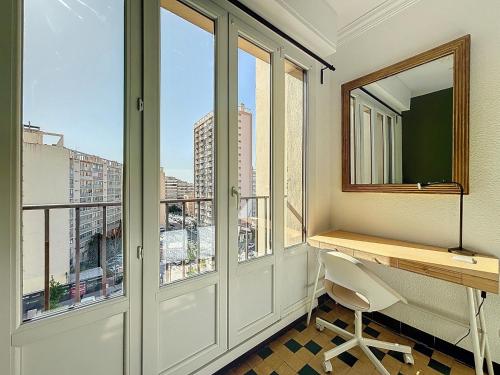 马赛Appartement 8 Couchages - Central & Spacieux - Les Frères de la Loc'的客房设有书桌和美景窗户。