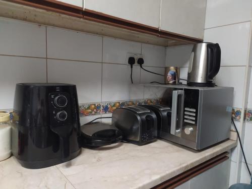沙迦Family Room In Sharjah的厨房柜台配有咖啡机和微波炉
