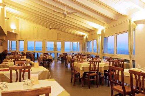 卡洛福泰帕乌拉酒店的用餐室设有桌椅和窗户。