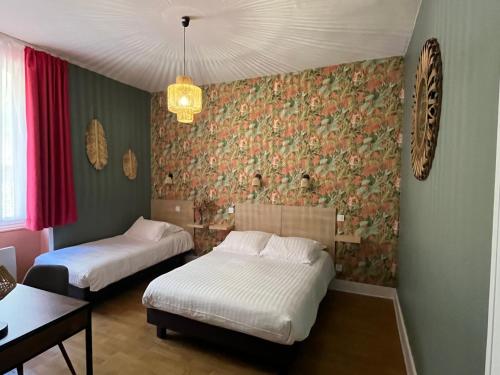 勒比格Logis Hôtel Le Cygne的一间卧室设有两张床,墙上挂着壁纸。