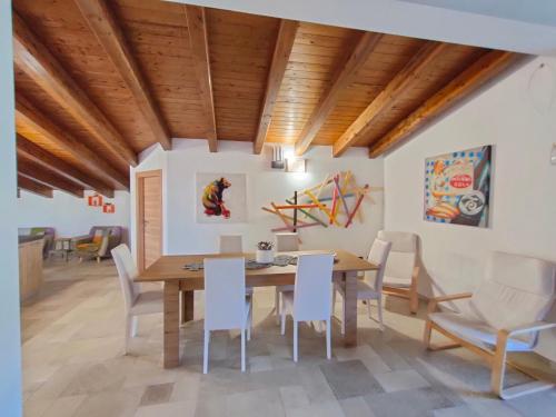 帕尔蒂尼科ATTICO GALILEO的一间带木桌和白色椅子的用餐室