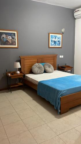 普拉亚Felicidade Hotel的一间卧室配有一张大床,提供蓝色的床单和枕头