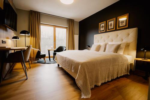 莫尔巴赫2tHEIMAT - Hotel & Restaurant的一间卧室配有一张大床、一张桌子和一张书桌