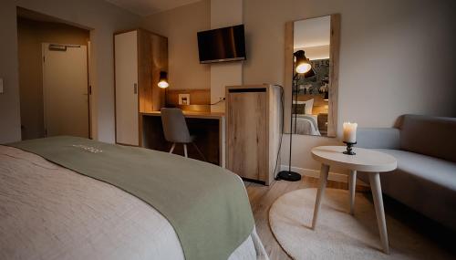 莫尔巴赫2tHEIMAT - Hotel & Restaurant的酒店客房设有一张床和一张带蜡烛的桌子。
