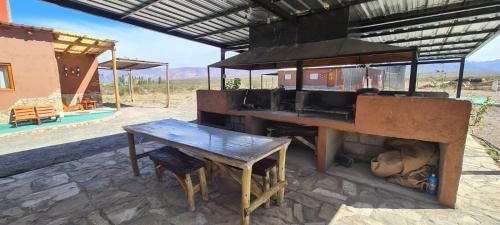乌斯帕亚塔科马尔卡宾馆的户外烧烤架,配有木桌、桌子和长凳