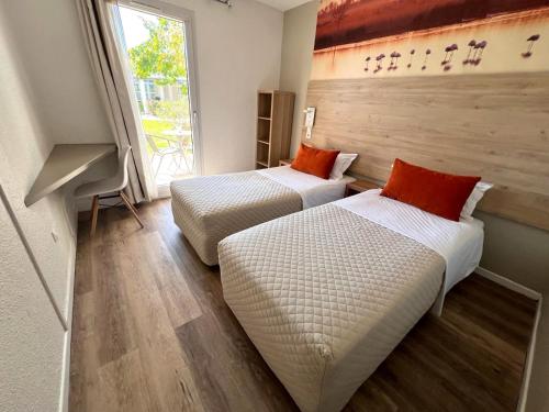 阿尔勒马斯德斯彭兹德阿莱斯酒店的带大窗户的客房内的两张床