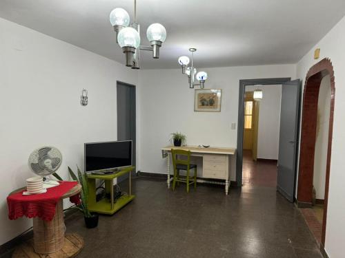 波萨达斯Casa céntrica muy comoda的客厅配有书桌和电视。