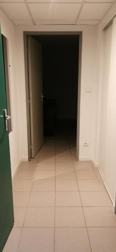 阿维尼翁Studio的一条空的走廊,有黑色的门,铺着瓷砖地板