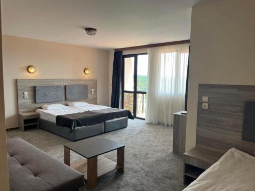 阿巴纳西Complex Bolyarsko selo & Spa的一间卧室配有一张床,客厅配有沙发