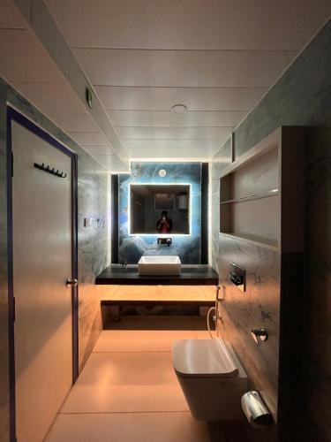 奈尼塔尔Spruce Hill Hotel & Restro的一间带卫生间的浴室和墙上的电视