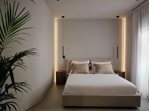 雅典Bond Smart Living Suites的卧室配有白色的床和植物