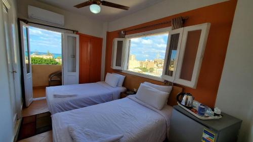 马特鲁港马沙马特鲁亚德里亚酒店的带2扇窗户的客房内的2张床