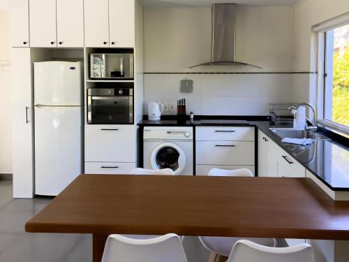 梅塞德斯Casa Country Altos Arrayanes的厨房配有木桌和白色家电